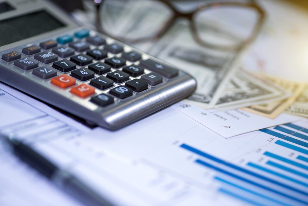 Calculator, pen and summary report on a table